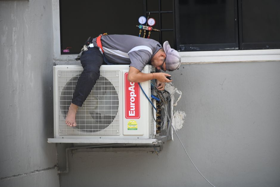 Technician diagnosing an indoor air handler during a repair visit